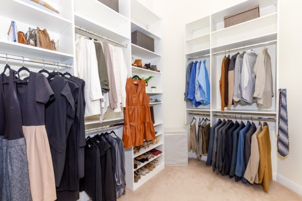 Luxurious walk-in closet with organized clothes, shoes on shelves, and hanging bags.