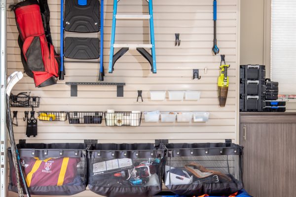 Organized garage with slatwall system storing tools, sports equipment, and various items.