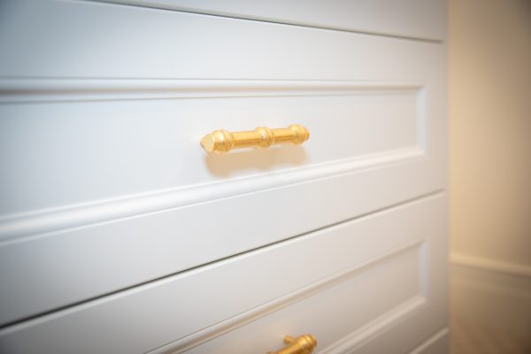 Light grey cabinet drawers with a gold bamboo-style handle.