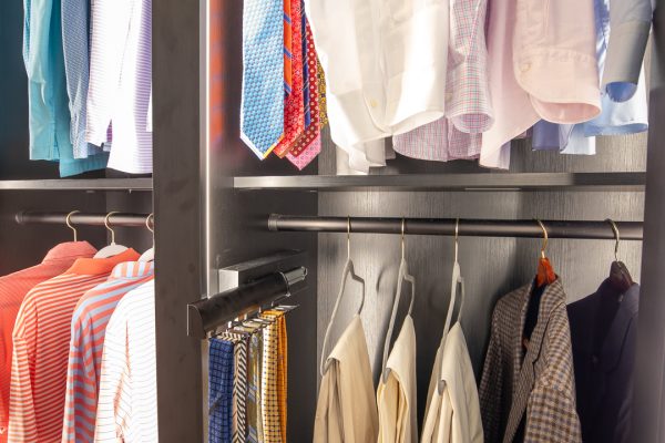 Custom closet with neatly organized men's shirts, ties, jackets, and slacks.