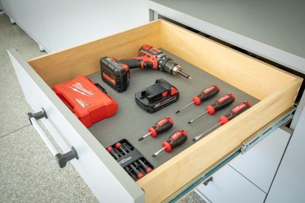 Open drawer with Milwaukee drill, batteries, and Hyper Tough screwdrivers on a gray liner.